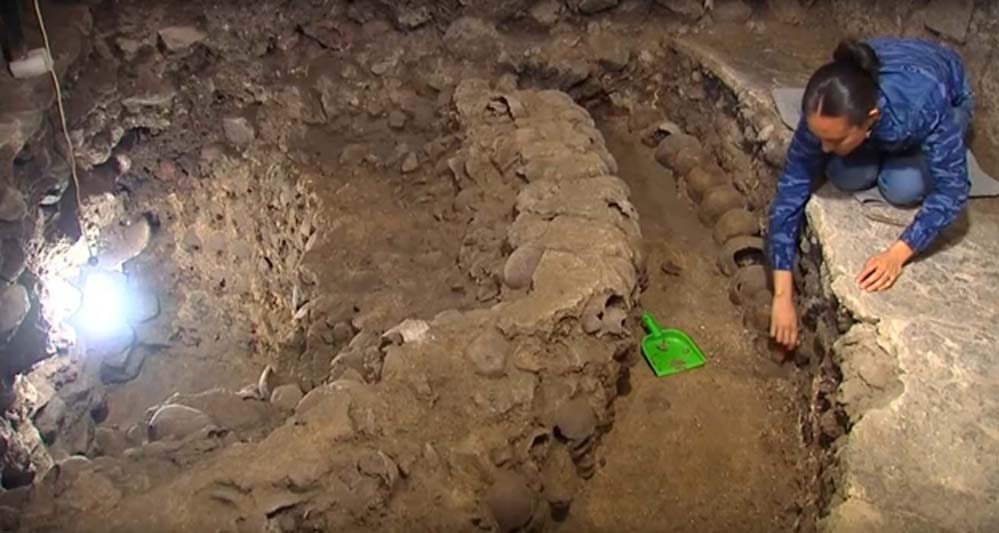 Arqueóloga del Instituto Nacional de Antropología e Historia de México (INAH) extrae calaveras de la macabra torre, en la que ya han sido descubiertos hasta ahora 650 cráneos humanos (Imagen: Youtube)