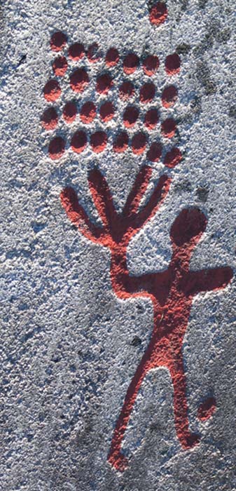 Figura humana y cazoletas. La profundidad de los grabados es claramente visible a la luz del atardecer. Arte rupestre de Tanum, Suecia. (CC BY SA 3.0)