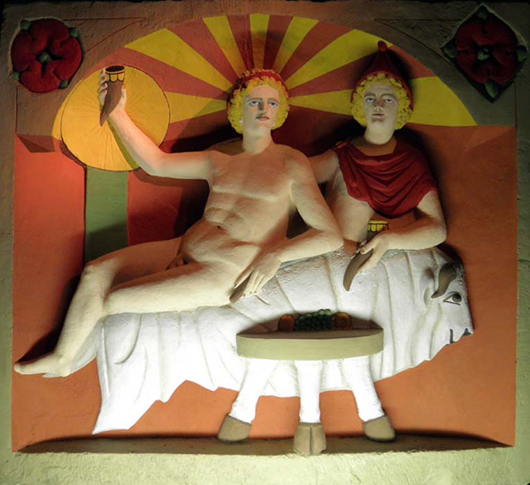 Reproducción de una escultura en la que Mitra y el dios sol participan de un banquete sentados sobre una piel de toro. (CC BY-SA 2.0)