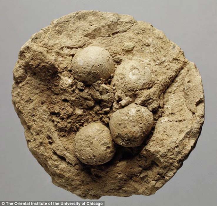 Fotografía de una de las bolas de arcilla mesopotámicas, partida por la mitad, en cuyo interior se observan elementos de menor tamaño (contadores o ‘fichas’) (Fotografía: Instituto Oriental de la Universidad de Chicago)