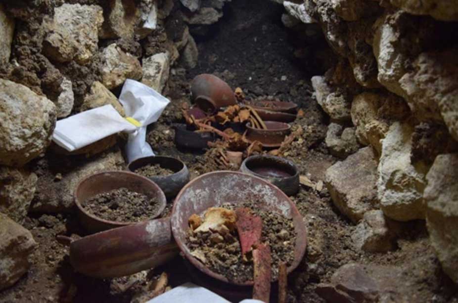 El Enterramiento 80 durante las excavaciones: en el centro se observa una copa de piedra rodeada de huesos. (Proyecto Arqueológico Waka’ y Ministerio de Cultura y Deportes de Guatemala)