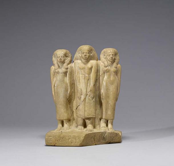 Grupo familiar, estatuilla de piedra caliza en la que se observa a un hombre en el centro, flanqueado por dos mujeres. Imperio Nuevo (c. 1850-1800 a. C.) (Public Domain)