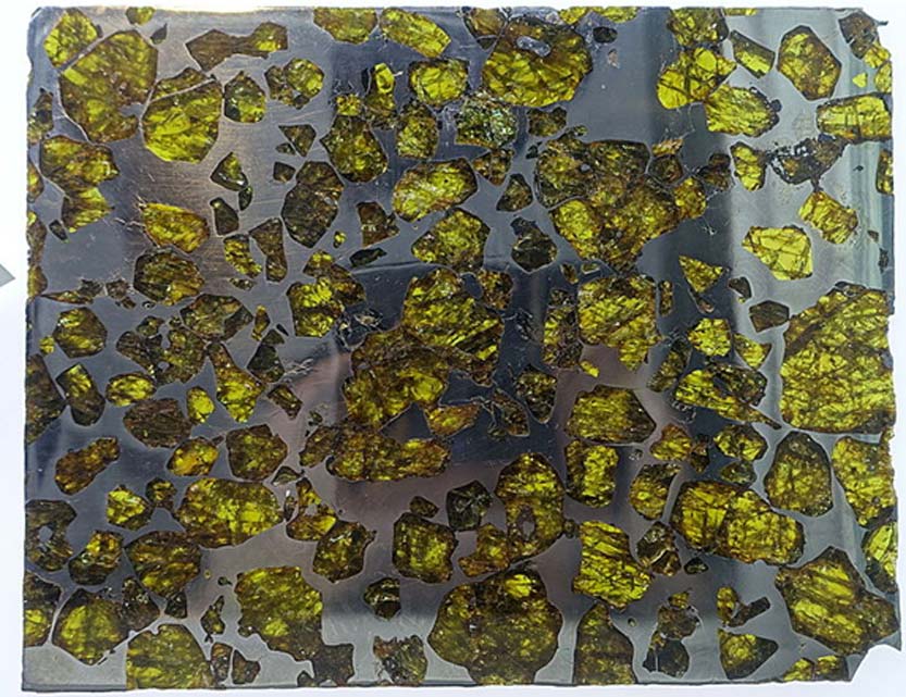 Lascas del meteorito de Fukang (pallasita) expuestas en el Centro para el Estudio de los Meteoritos de la Universidad Estatal de Arizona con sede en Tampa, Arizona, Estados Unidos. (Public Domain)