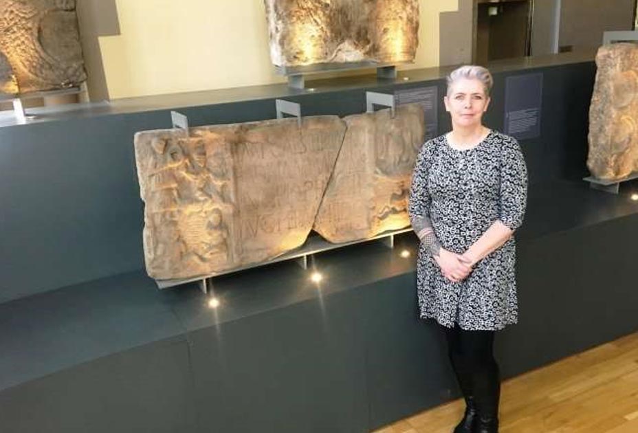 La Dra. Louisa Campbell con la piedra de Summerston en el Museo Hunterian. (Universidad de Glasgow)