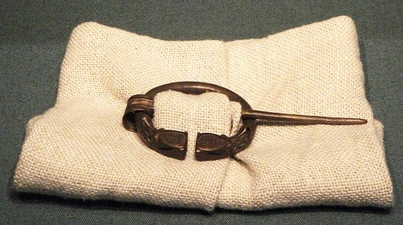 Modelo de antiguo broche junto con pieza de tela, mostrando cómo se empleaban antiguamente estos broches. Museo Británico. (Johnbod/CC BY SA 3.0)