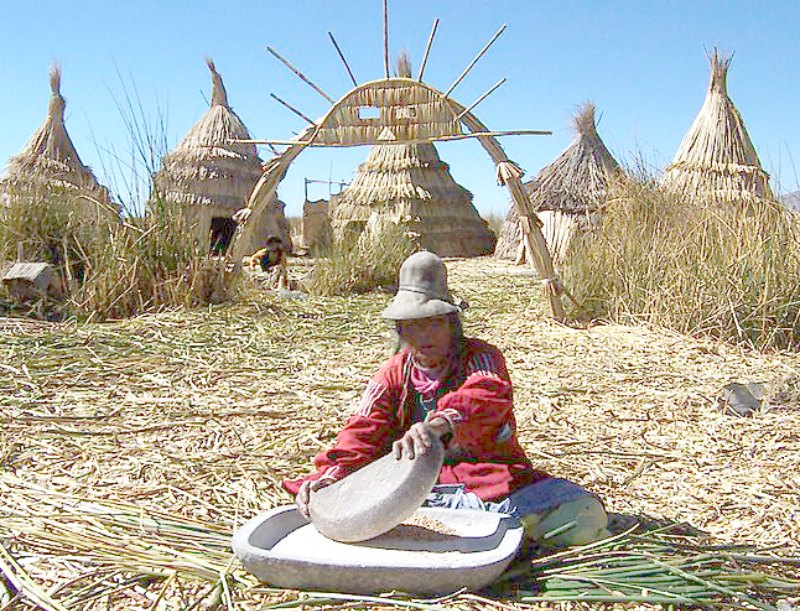 Mujer uru moliendo maíz sobre una isla flotante de totora. (Fedekuki/CC BY-SA 3.0)