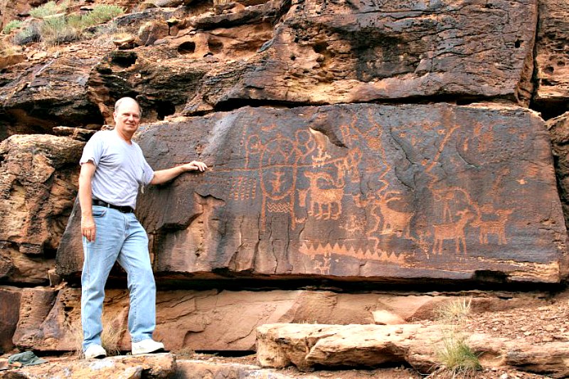 John A. Ruskamp ante algunos petroglifos hallados en Utah, Estados Unidos, cercanos a los que presentan antigua escritura china, según él mismo defiende. (Fotografía: Cortesía de John A. Ruskamp/La Gran Época)