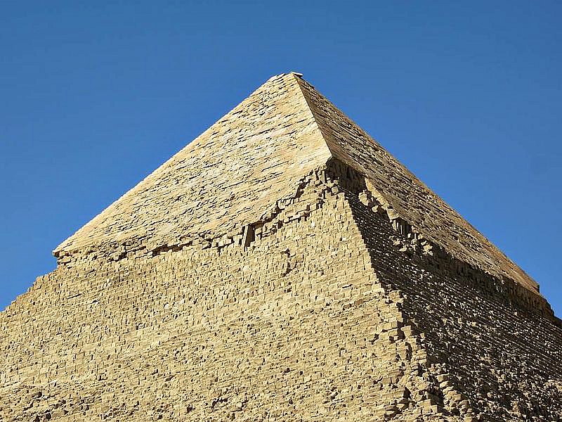 La parte superior de la Pirámide de Kefrén ubicada en Guiza (Egipto), aún se encuentra revestida de piedra caliza blanca. A lo largo de los siglos, este revestimiento fue extraído para obtener materiales de la construcción, pero en la antigüedad su piedra pulida resplandecía con su brillo en el desierto. (David Stanley/CC BY-SA 2.0)