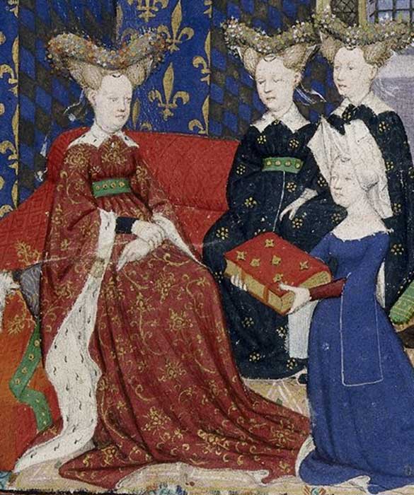 Christine de Pisan presenta su libro a la reina Isabeau de Francia. Tanto ella como sus damas lucen “bourrelets” enjoyados con forma de corazón sobre un peinado que se asemeja a cuernos. Christine, por su parte, lleva puesto un hennin de dos puntas cubierto por una tela blanca. (Public Domain)