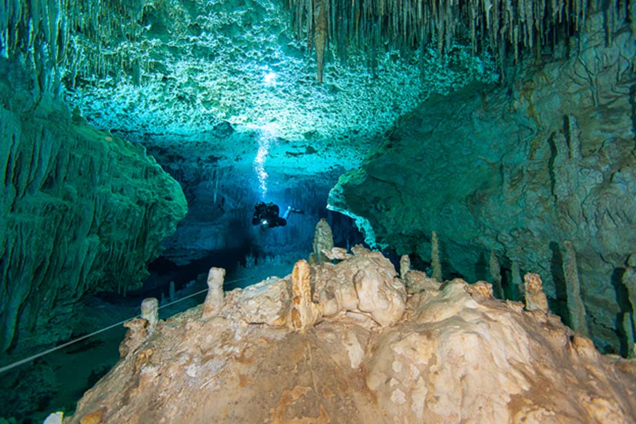 Submarinista buceando en uno de los espectaculares pasadizos decorados del sistema de cuevas del cenote Chan Hol, México. (Alison Perkins/Underwater Project)