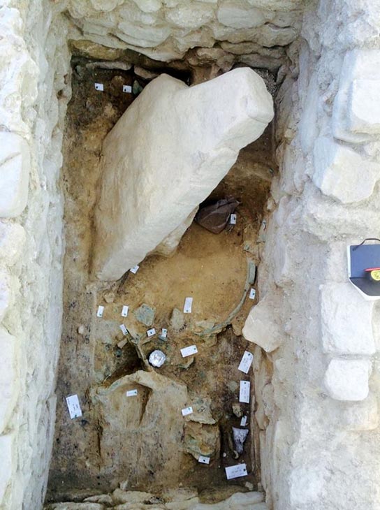 Vista de la tumba del Guerrero del Grifo. Obsérvese la losa de piedra caída en su interior. (Griffin Warrior Tomb)