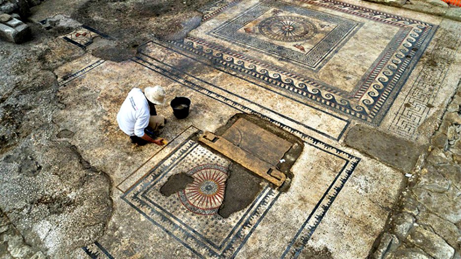 Portada - Arqueólogo trabajando sobre uno de los grandes mosaicos descubiertos recientemente en el sur de Francia. (Fotografía: RT/inrap.fr)