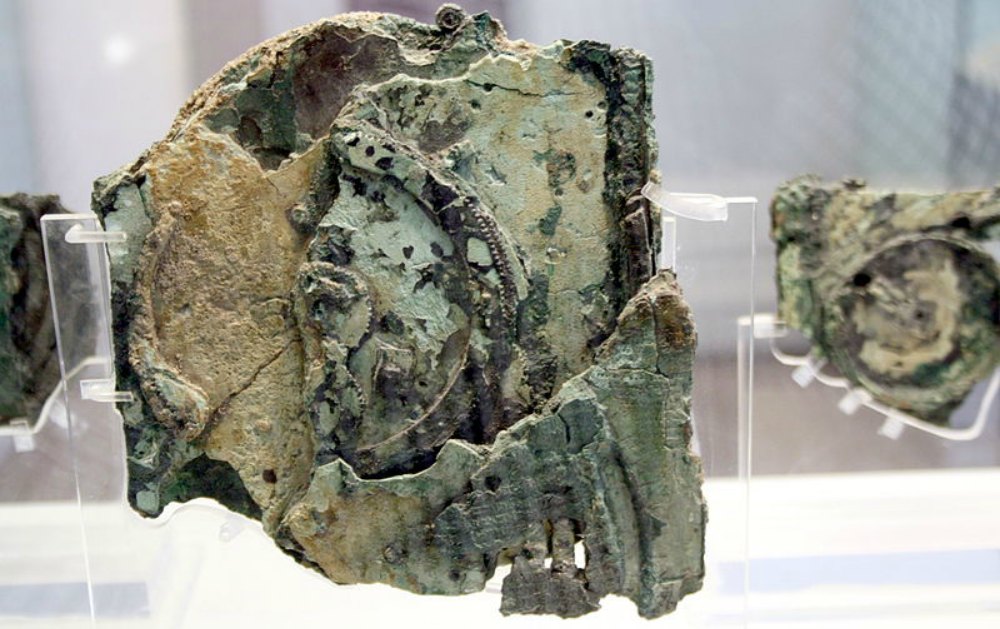 Portada - Primer plano de uno de los fragmentos del mecanismo de Anticitera que aún se conservan en la actualidad. Museo Arqueológico Nacional de Atenas, Grecia. (Public Domain)