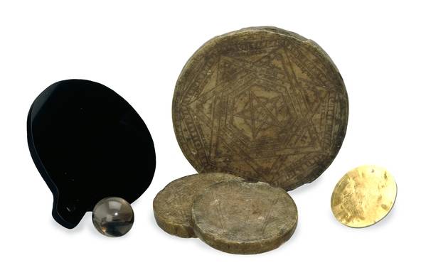 Los instrumentos mágicos de John Dee: discos de cera y de oro, una esfera de cuarzo y un espejo de obsidiana pulida. WikiCommons