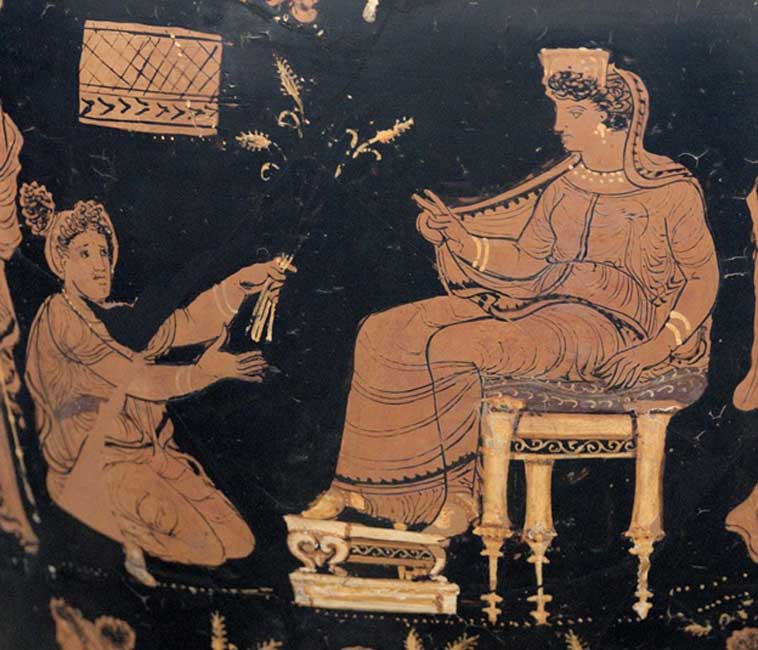 Deméter, sentada en su trono, extiende su mano para bendecir a Metanira, arrodillada ante ella, quien le presenta como ofrenda el trigo trino, un símbolo recurrente de los misterios (Public Domain)