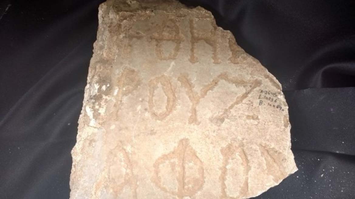 Fragmento de una antigua inscripción griega hallada en el transcurso de las excavaciones realizadas en Cesarea en abril del 2017. (Ilan Ben Zion/Times of Israel)