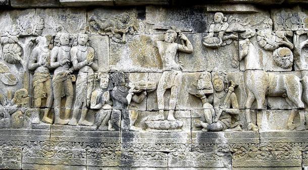 El Príncipe Siddhartha Gautama se afeita la cabeza como signo de la caída de su estatus como ksatriya (clase guerrera)  y se convierte en un ermitaño, su sirviente sujeta la espada, corona y joyas de príncipe mientras su caballo Kanthaka está de pie a su derecha. Panel bajo relieve en Borobudur, Java, Indonesia. 