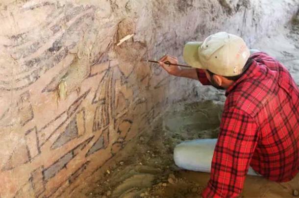 Sâm Ghavami usa un pincel para revelar el mural, apodado la Huaca Pintada peruana. (Sâm Ghavami)