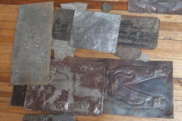 Placas metálicas talladas de la colección del padre Crespi esparcidas por el suelo de un edificio antiguo en ruinas. Crédito: Ancient-Origins.es
